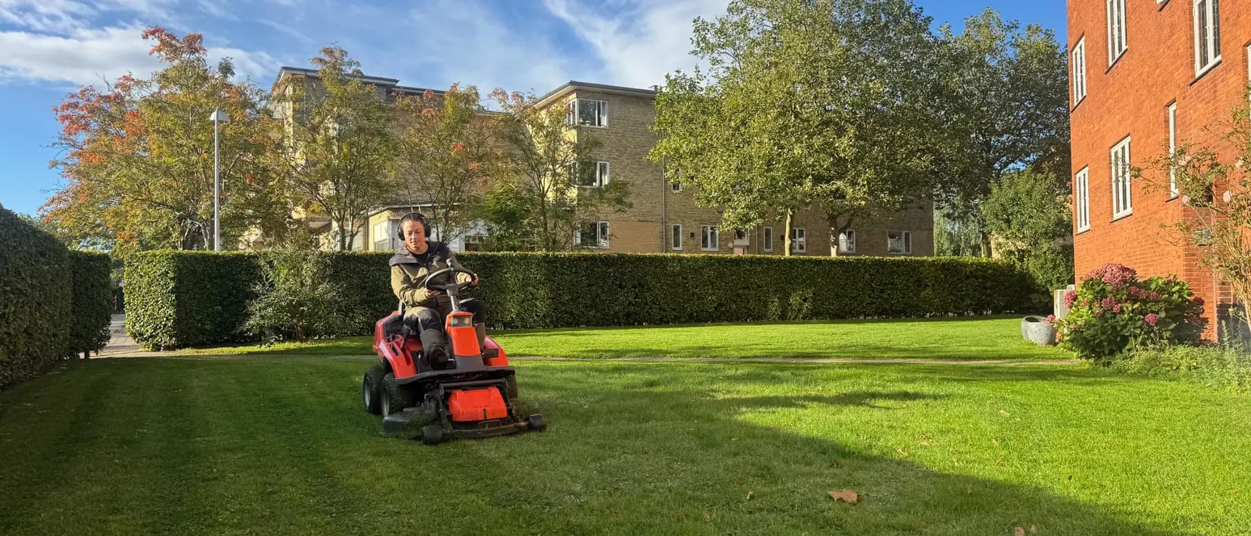 En medarbejder fra Vaskekonerne, der vedligeholder grønne arealer ved en boligforening